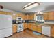 Functional kitchen featuring wood cabinets, white appliances, and a well-lit workspace at 35550 Running Brook Ln, Elizabeth, CO 80107