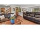 Spacious living room with wood floors, leather sofas, and an open doorway to the dining area at 35550 Running Brook Ln, Elizabeth, CO 80107