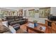 Cozy living room with leather furniture, a stone fireplace, and large windows offering views of the outdoors at 35550 Running Brook Ln, Elizabeth, CO 80107