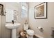 Elegant powder room featuring a pedestal sink, toilet, and decorative artwork at 1669 Stable View Dr, Castle Pines, CO 80108