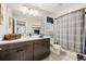 Bathroom vanity featuring a sink, wooden cabinets and a decorative mirror and shower with curtain at 1669 Stable View Dr, Castle Pines, CO 80108