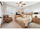 Bright bedroom featuring neutral walls, wood furniture, and a colorful accent chair and curtains at 1669 Stable View Dr, Castle Pines, CO 80108