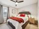 Cozy bedroom with tufted headboard, red accent pillows, a ceiling fan, and lots of natural light at 1669 Stable View Dr, Castle Pines, CO 80108