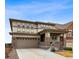 Inviting two-story home featuring a covered front porch and attached two-car garage at 1669 Stable View Dr, Castle Pines, CO 80108