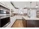 Modern kitchen features white cabinets, stainless steel appliances, dark island, and hardwood floors at 1669 Stable View Dr, Castle Pines, CO 80108