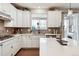Well-lit kitchen with white cabinets, stainless steel appliances, a gray backsplash, and hardwood floors at 1669 Stable View Dr, Castle Pines, CO 80108