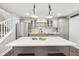 Bright kitchen with quartz island, stainless steel refrigerator, modern grey cabinetry and wood floors at 1669 Stable View Dr, Castle Pines, CO 80108