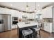 Bright kitchen boasts white cabinets, stainless steel appliances, a gray backsplash and island seating at 1669 Stable View Dr, Castle Pines, CO 80108