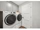 Convenient laundry room with a large washing machine and dryer and upper cabinets at 1669 Stable View Dr, Castle Pines, CO 80108