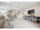 Spacious basement living room with plush carpeting, gray sofa and entertainment center, and neutral walls at 1669 Stable View Dr, Castle Pines, CO 80108