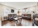 Open living room featuring hardwood floors, leather couches, and natural light at 1669 Stable View Dr, Castle Pines, CO 80108