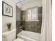 Cozy bathroom with tiled walls, a bathtub with shower, and contemporary fixtures at 732 Poplar St, Denver, CO 80220