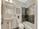 Elegant bathroom featuring a pedestal sink and tiled tub surround with natural light at 732 Poplar St, Denver, CO 80220