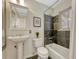 Bathroom featuring a pedestal sink, modern fixtures, and a bathtub with unique tile surround at 732 Poplar St, Denver, CO 80220