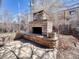 Outdoor fireplace constructed of light-colored stones with seating ledge and stone patio at 732 Poplar St, Denver, CO 80220