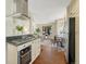 Open concept kitchen with gas range, stainless appliances, and hardwood floors at 732 Poplar St, Denver, CO 80220
