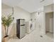 Functional laundry room includes a washer, dryer, and mini-fridge, set on tiled flooring at 732 Poplar St, Denver, CO 80220