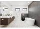 Bathroom with double vanity, soaking tub, and geometric tile at 6435 E 6Th Avenue Pkwy, Denver, CO 80220