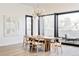 Modern dining room with a long wooden table and access to a balcony at 6435 E 6Th Avenue Pkwy, Denver, CO 80220