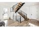 Modern floating staircase with black metal railings and light wood steps at 6435 E 6Th Avenue Pkwy, Denver, CO 80220