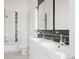 Modern bathroom featuring double sinks, sleek cabinetry, and tiled walls, exuding contemporary elegance at 1810 E 33Rd Ave, Denver, CO 80205