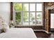 Bright bedroom featuring large windows, exposed brick, and dark hardwood floors for urban living at 1810 E 33Rd Ave, Denver, CO 80205
