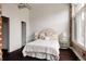 Sun-filled bedroom with a decorative headboard, exposed brick, and hardwood floors provides a comfy vibe at 1810 E 33Rd Ave, Denver, CO 80205
