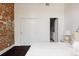 Bedroom with painted brick, closet, dark wood floors, and ensuite bathroom, offering a blend of style and function at 1810 E 33Rd Ave, Denver, CO 80205