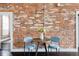 Cozy dining area with a wooden table, blue chairs, and exposed brick wall at 1810 E 33Rd Ave, Denver, CO 80205