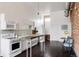 Bright white kitchen with a modern island, stainless steel appliances, and dark wood floors at 1810 E 33Rd Ave, Denver, CO 80205