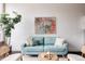 Stylish living room featuring a comfortable blue couch, artwork and a green plant at 1810 E 33Rd Ave, Denver, CO 80205