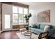 Bright living room with exposed brick, a cozy blue couch, and plenty of natural light at 1810 E 33Rd Ave, Denver, CO 80205