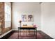 Bright office area with floral artwork, a sleek desk, and exposed brick, perfect for a creative workspace at 1810 E 33Rd Ave, Denver, CO 80205