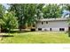Large backyard with mature trees, well-kept lawn, and the house with large windows at 5389 W Roxbury Pl, Littleton, CO 80128