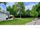 Spacious backyard with green grass, mature trees, and a patio area with seating at 5389 W Roxbury Pl, Littleton, CO 80128