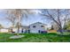 A beautiful backyard with green grass, mature trees, patio, and outdoor seating at 5389 W Roxbury Pl, Littleton, CO 80128