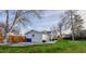 Spacious backyard with a patio area, large trees, privacy fence, and lush green lawn at 5389 W Roxbury Pl, Littleton, CO 80128