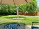 Backyard featuring green grass, mature trees, and a fire pit at 5389 W Roxbury Pl, Littleton, CO 80128