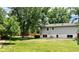 Spacious backyard with lush green lawn, mature trees, and the exterior of the house in the background at 5389 W Roxbury Pl, Littleton, CO 80128