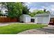 Backyard featuring two storage sheds and a grass area with a wooden fence at 5389 W Roxbury Pl, Littleton, CO 80128