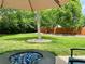 Landscaped backyard with a large tree, a fire pit, and a wooden fence, creating a private outdoor space at 5389 W Roxbury Pl, Littleton, CO 80128