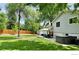Large backyard with green lawn, mature trees, wooden fence and patio with seating at 5389 W Roxbury Pl, Littleton, CO 80128