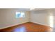 Finished basement area with hardwood floors and a window offering natural light, suitable for various uses at 5389 W Roxbury Pl, Littleton, CO 80128