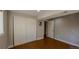 This bedroom features a closet and open doorway to another room, wood floors, and is brightly lit at 5389 W Roxbury Pl, Littleton, CO 80128