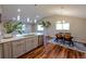 Modern kitchen featuring an island, stainless steel appliances and dining area with hardwood floors at 5389 W Roxbury Pl, Littleton, CO 80128
