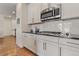 Modern kitchen with white cabinets, granite countertops, and gas cooktop at 6484 S Harvest St, Aurora, CO 80016