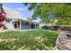 Beautiful backyard with lush lawn, mature trees, and a covered patio ideal for entertainment and outdoor enjoyment at 12218 Monroe Dr, Thornton, CO 80241
