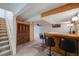 Finished basement with a wet bar, carpet flooring, and a staircase at 12218 Monroe Dr, Thornton, CO 80241