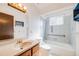 Well-lit bathroom featuring a vanity with a large mirror, toilet, and shower-tub combination at 12218 Monroe Dr, Thornton, CO 80241