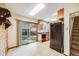 Well-lit kitchen with tile flooring, wood cabinets, black appliances, and access to the backyard at 12218 Monroe Dr, Thornton, CO 80241